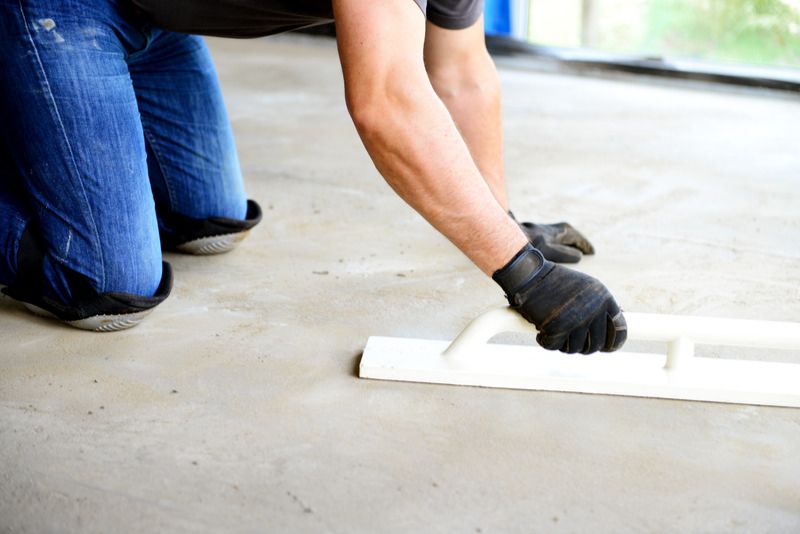 concrete worker manually polishing concrete floor